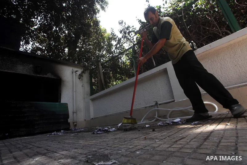 Egyptian Men remove the damages in the burnt campaign headquarters of candidate and former prime minister Ahmed Shafiq in Cairo May 29, 2012. A group of Egyptian protesters set fire to the headquarters on Monday, the sta...