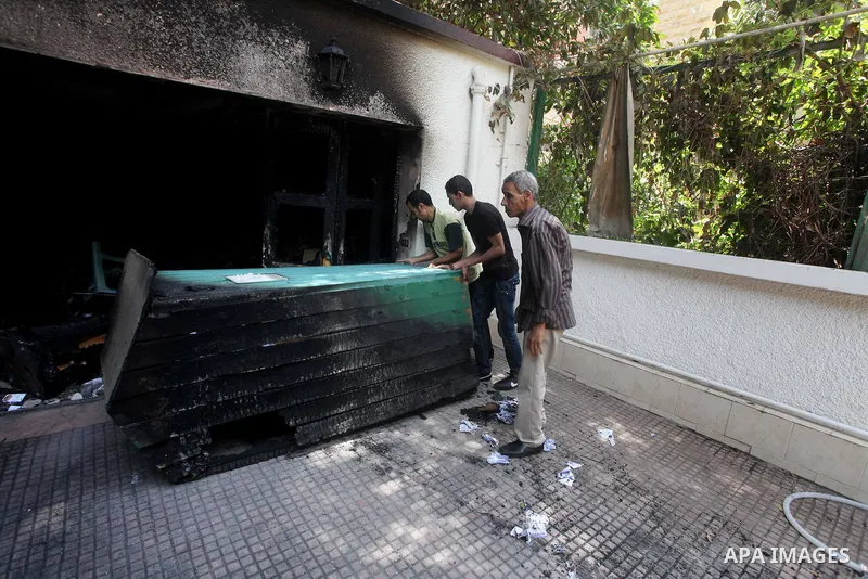 Egyptian Men remove the damages in the burnt campaign headquarters of candidate and former prime minister Ahmed Shafiq in Cairo May 29, 2012. A group of Egyptian protesters set fire to the headquarters on Monday, the sta...