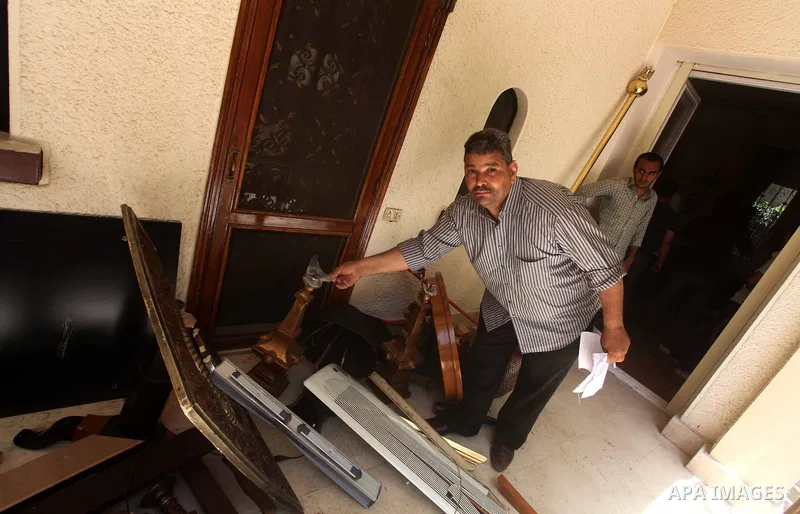 Egyptian men check the scene inside the burnt campaign headquarters of candidate and former prime minister Ahmed Shafiq in Cairo May 29, 2012. A group of Egyptian protesters set fire to the headquarters on Monday, the st...