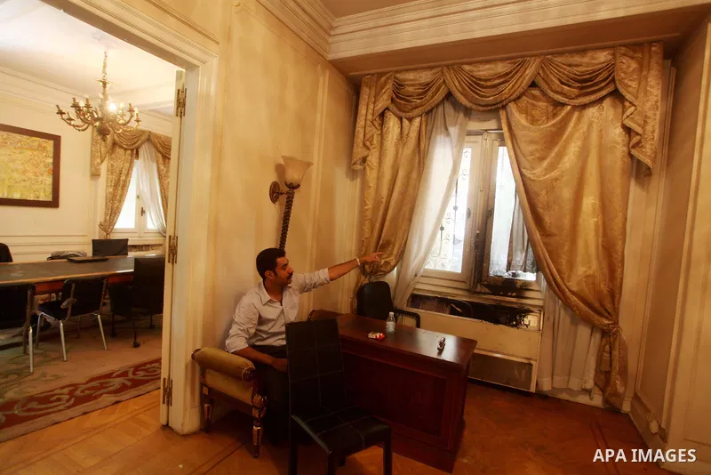 A man checks the scene inside the burnt campaign headquarters of candidate and former prime minister Ahmed Shafiq in Cairo May 29, 2012. A group of Egyptian protesters set fire to the headquarters on Monday, the state ne...