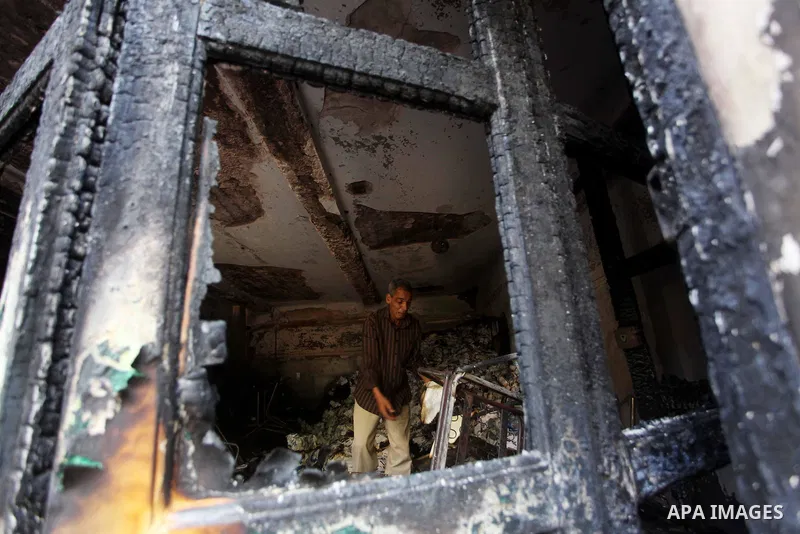 A man checks the scene inside the burnt campaign headquarters of candidate and former prime minister Ahmed Shafiq in Cairo May 29, 2012. A group of Egyptian protesters set fire to the headquarters on Monday, the state ne...