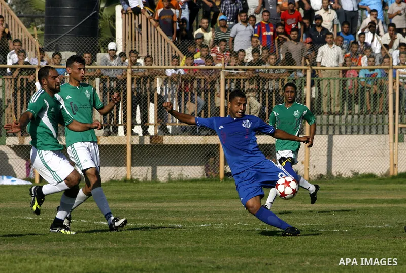 Players from Rafah Youth Club play against the players from Rafah Services Club during a football match in the League Cup of the Gaza Strip at Rafah Municipality Stadium in the southern Gaza Strip on May 30, 2012. Photo...