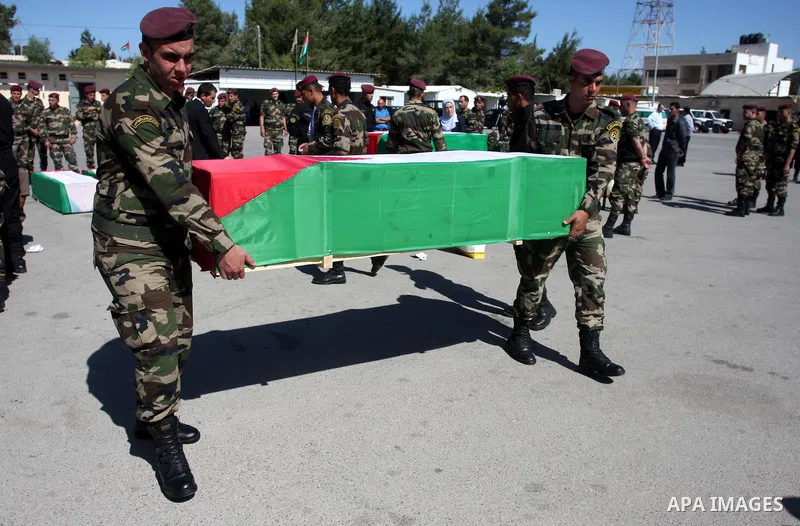 Palestinian security forces carry flag-draped coffins during preparations for the funeral procession of 91 Palestinians whose remains were returned by Israel in the West Bank city of Ramallah on May 31, 2012. Israel hand...