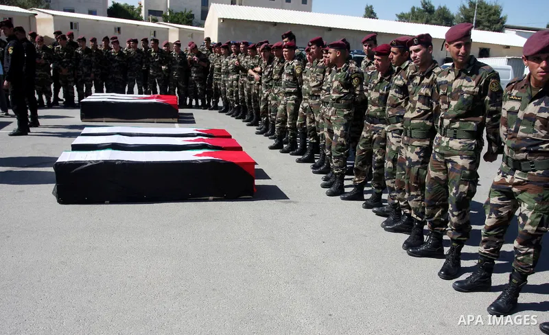 Palestinian security forces carry flag-draped coffins during preparations for the funeral procession of 91 Palestinians whose remains were returned by Israel in the West Bank city of Ramallah on May 31, 2012. Israel hand...
