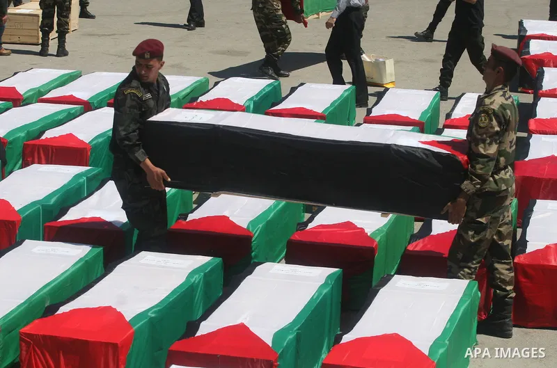 Palestinian security forces carry flag-draped coffins during preparations for the funeral procession of 91 Palestinians whose remains were returned by Israel in the West Bank city of Ramallah on May 31, 2012. Israel hand...