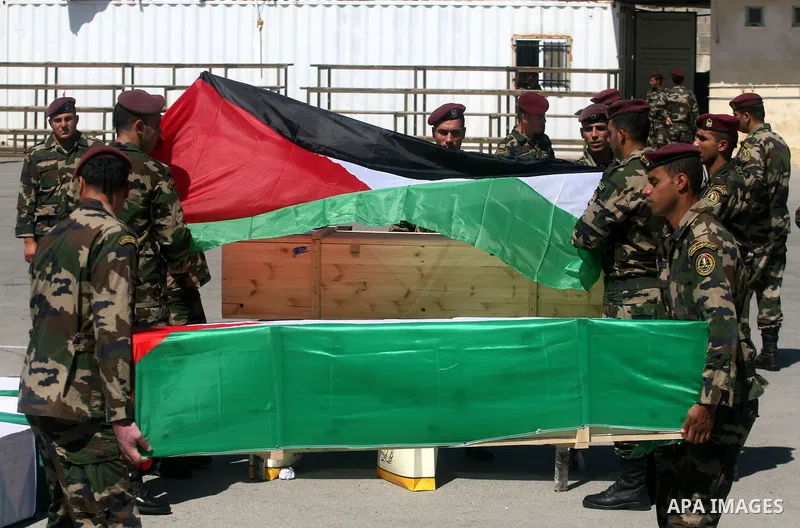 Palestinian security forces carry flag-draped coffins during preparations for the funeral procession of 91 Palestinians whose remains were returned by Israel in the West Bank city of Ramallah on May 31, 2012. Israel hand...