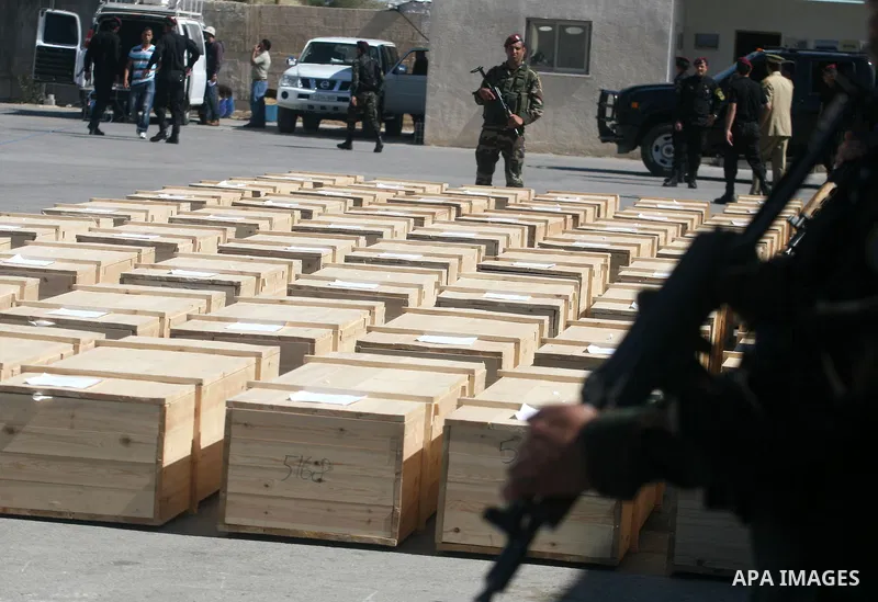 Palestinian security forces carry flag-draped coffins during preparations for the funeral procession of 91 Palestinians whose remains were returned by Israel in the West Bank city of Ramallah on May 31, 2012. Israel hand...