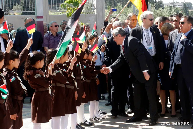 German President Joachim Gauck is greeted by Palestinian girls upon his arrival to the West Bank village of Burin, south of Nablus, to attend the inauguration of a German-funded girls' school on May 31, 2012. Photo by Wa...