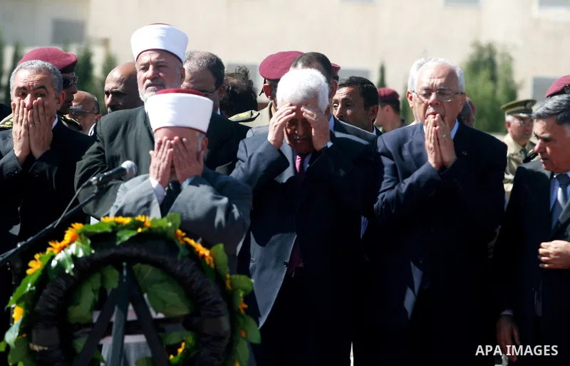 Palestinians pray over flag-draped coffins during the funeral of 91 Palestinians whose remains were returned by Israel at the Palestinian leadership headquarters in the West Bank city of Ramallah on May 31, 2012. Israel...