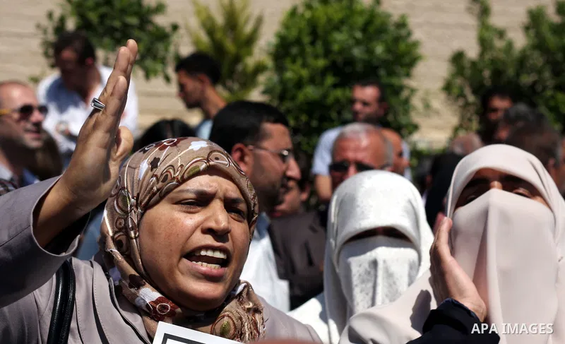 Relatives react as they carry flag-drapped coffins containing the remains of Palestinian militants dafter an official ceremony at the President's headquarter in the West Bank town of Ramallah, 31 May 2012. Israel handed...