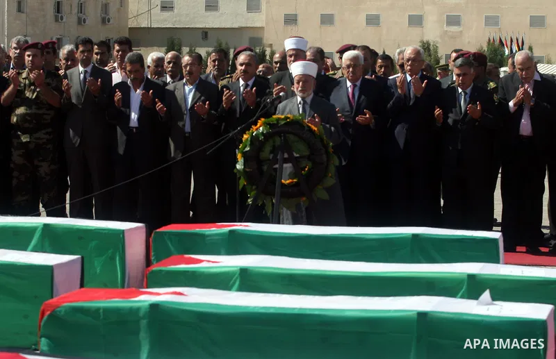Palestinians pray over flag-draped coffins during the funeral of 91 Palestinians whose remains were returned by Israel at the Palestinian leadership headquarters in the West Bank city of Ramallah on May 31, 2012. Israel...