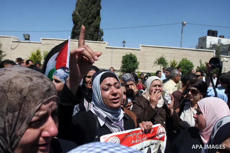 Relatives react as they carry flag-drapped coffins containing the remains of Palestinian militants dafter an official ceremony at the President's headquarter in the West Bank town of Ramallah, 31 May 2012. Israel handed...