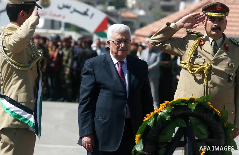 Palestinian President Mahmoud Abbas (C) prays over flag-draped coffins during the funeral of 91 Palestinians whose remains were returned by Israel at the Palestinian leadership headquarters in the West Bank city of Ramal...