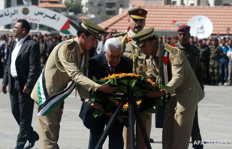 Palestinian President Mahmoud Abbas (C) prays over flag-draped coffins during the funeral of 91 Palestinians whose remains were returned by Israel at the Palestinian leadership headquarters in the West Bank city of Ramal...