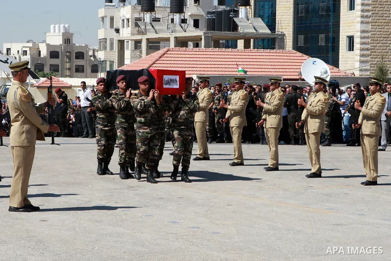 Members of the Palestinian security forces carry flag-covered coffins containing the remains of Palestinian militants during an official ceremony in the West Bank city of Ramallah May 31, 2012. The remains of 91 Palestin...