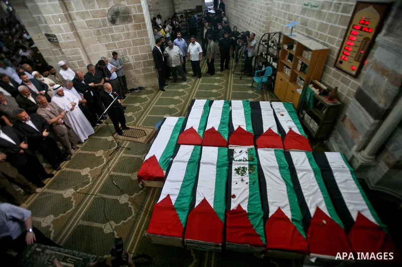 Palestinians pray next to flag-covered coffins containing the remains of Palestinian militants in a mosque in Gaza City May 31, 2012. The remains of 91 Palestinian militants whose attacks killed hundreds of Israelis over...