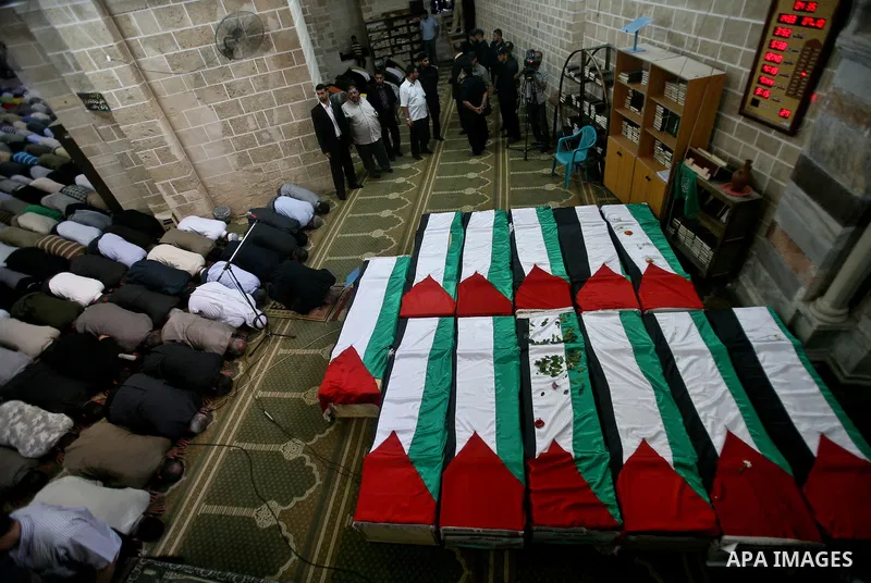 Palestinians pray next to flag-covered coffins containing the remains of Palestinian militants in a mosque in Gaza City May 31, 2012. The remains of 91 Palestinian militants whose attacks killed hundreds of Israelis over...
