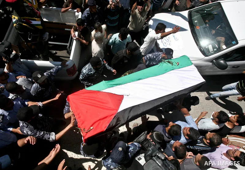 Relatives and masked Palestinian militants carry flag-drapped coffins containing the remains of Palestinian militants after the arrival of the caskets in Gaza City, 31 May 2012. Israel handed over the remains of dozens o...