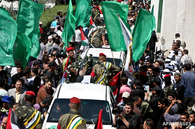 Relatives and masked Palestinian militants carry flag-drapped coffins containing the remains of Palestinian militants after the arrival of the caskets in Gaza City, 31 May 2012. Israel handed over the remains of dozens o...