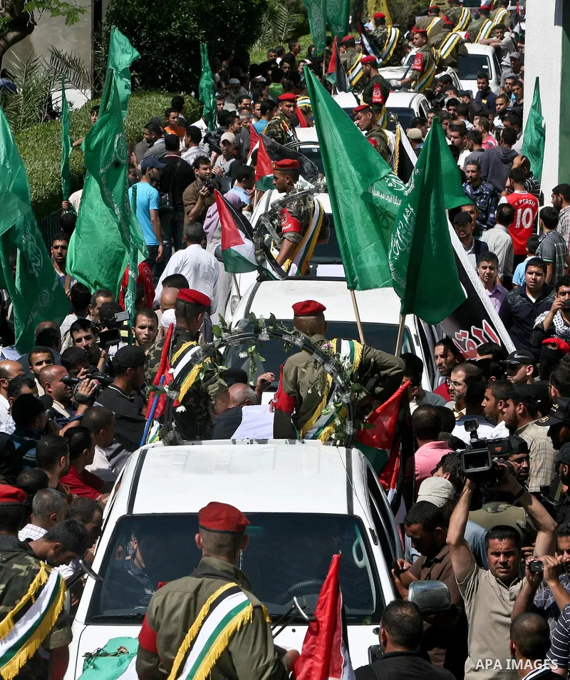 Relatives and masked Palestinian militants carry flag-drapped coffins containing the remains of Palestinian militants after the arrival of the caskets in Gaza City, 31 May 2012. Israel handed over the remains of dozens o...