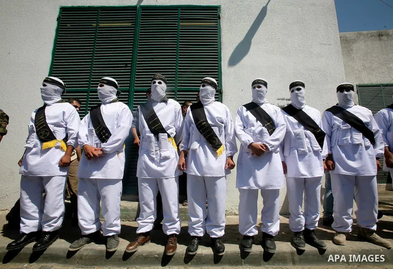 Relatives and masked Palestinian militants carry flag-drapped coffins containing the remains of Palestinian militants after the arrival of the caskets in Gaza City, 31 May 2012. Israel handed over the remains of dozens o...