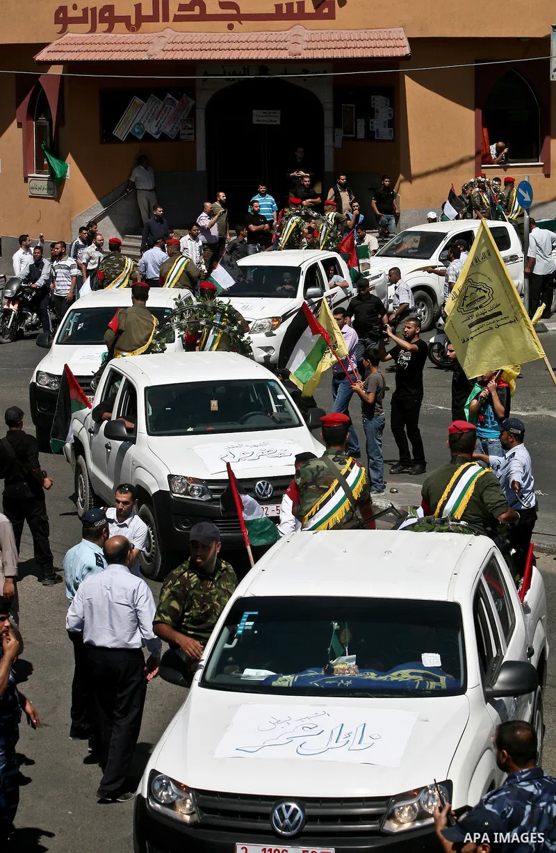 Relatives and masked Palestinian militants carry flag-drapped coffins containing the remains of Palestinian militants after the arrival of the caskets in Gaza City, 31 May 2012. Israel handed over the remains of dozens o...