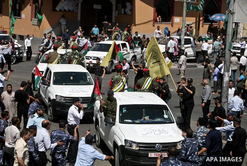 Relatives and masked Palestinian militants carry flag-drapped coffins containing the remains of Palestinian militants after the arrival of the caskets in Gaza City, 31 May 2012. Israel handed over the remains of dozens o...