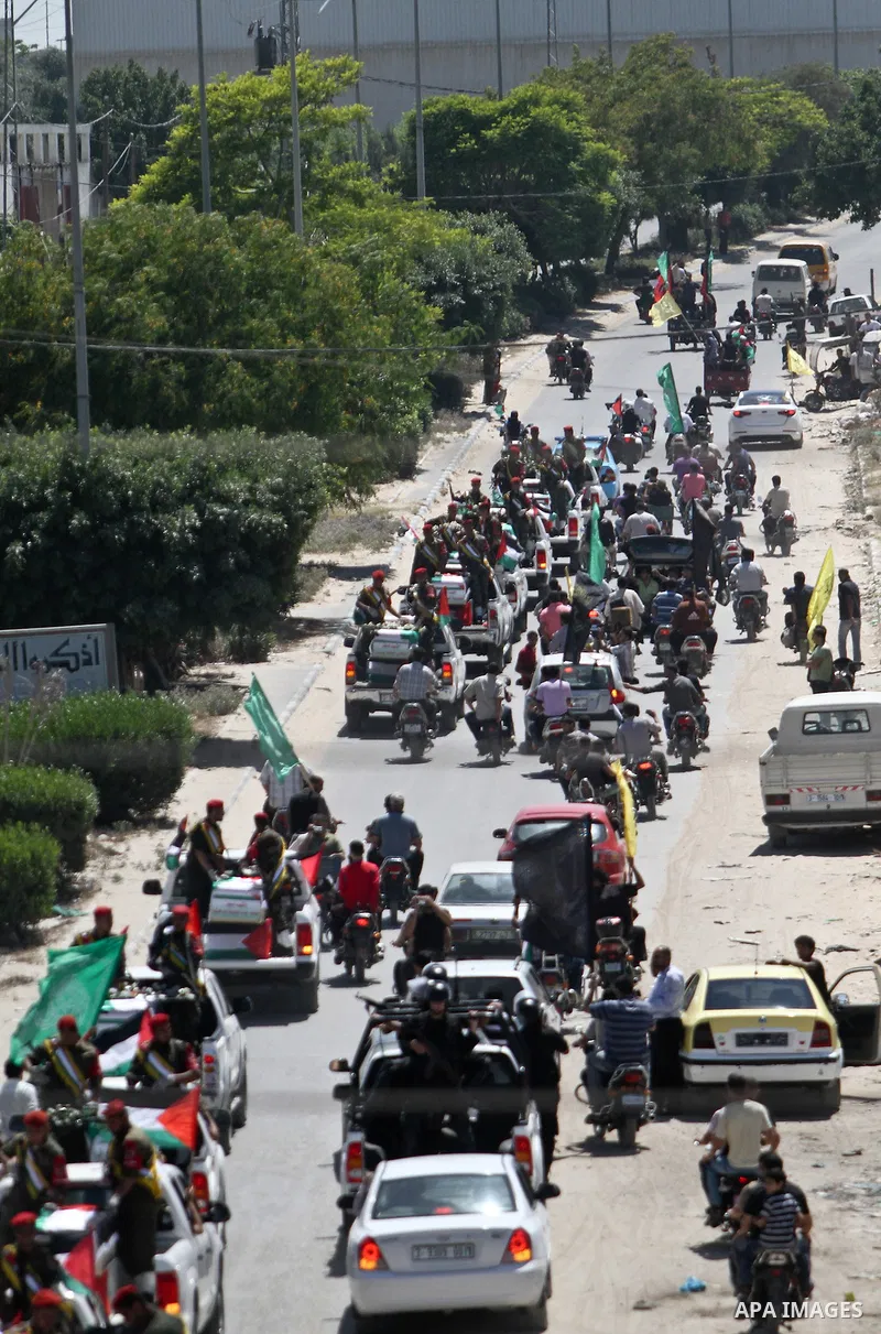Relatives and masked Palestinian militants carry flag-drapped coffins containing the remains of Palestinian militants after the arrival of the caskets in Gaza City, 31 May 2012. Israel handed over the remains of dozens o...