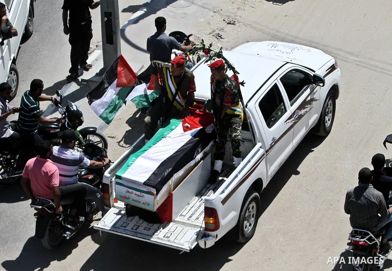 Relatives and masked Palestinian militants carry flag-drapped coffins containing the remains of Palestinian militants after the arrival of the caskets in Gaza City, 31 May 2012. Israel handed over the remains of dozens o...