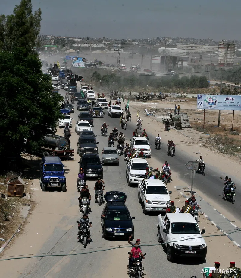Relatives and masked Palestinian militants carry flag-drapped coffins containing the remains of Palestinian militants after the arrival of the caskets in Gaza City, 31 May 2012. Israel handed over the remains of dozens o...