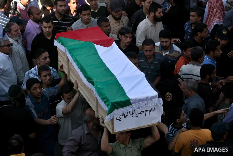 Relatives and masked Palestinian militants carry flag-drapped coffins containing the remains of Palestinian militants after the arrival of the caskets in Gaza City, 31 May 2012. Israel handed over the remains of dozens o...