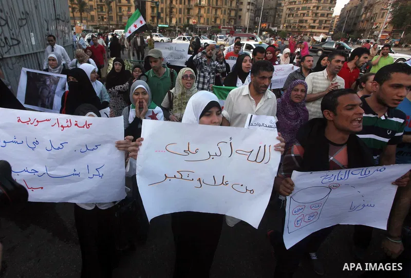 Syrians living in Egypt shout slogans as they protest against the weekend massacre of Houla, in front of the Syrian embassy in Cairo, Egypt, 31 May 2012. A massacre was reported in the central Syrian city of Houla over t...