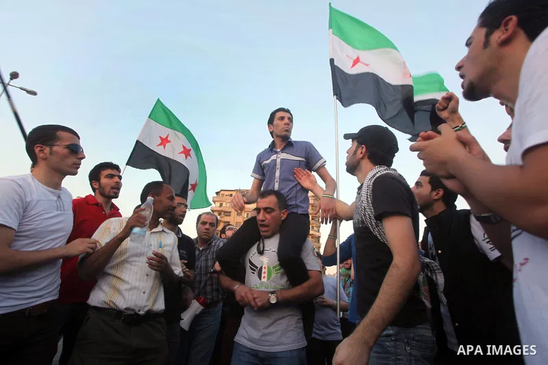 Syrians living in Egypt wave the revolutionary flag and shout slogans as they protest against the weekend massacre of Houla, in front of the Syrian embassy in Cairo, Egypt, 31 May 2012. A massacre was reported in the cen...