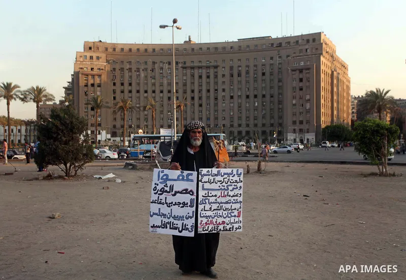 Egyptian Protester holds slogans during a protest against candidate Ahmed Shafiq, at Tahrir Square in Cairo May 31, 2012. The prospect of Shafiq succeeding Hosni Mubarak as president of Egypt is a nightmare for revolutio...