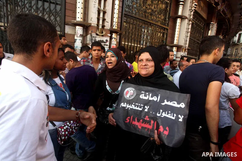 Egyptian Protester holds slogans during a protest against candidate Ahmed Shafiq, at Tahrir Square in Cairo May 31, 2012. The prospect of Shafiq succeeding Hosni Mubarak as president of Egypt is a nightmare for revolutio...