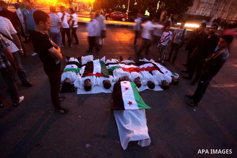 Protesters show solidarity with victims of massacre of Houla during a protest in front of the Syrian embassy in Cairo, Egypt, 31 May 2012. A massacre was reported in the central Syrian city of Houla over the weekend, how...