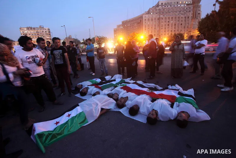 Protesters show solidarity with victims of massacre of Houla during a protest in front of the Syrian embassy in Cairo, Egypt, 31 May 2012. A massacre was reported in the central Syrian city of Houla over the weekend, how...