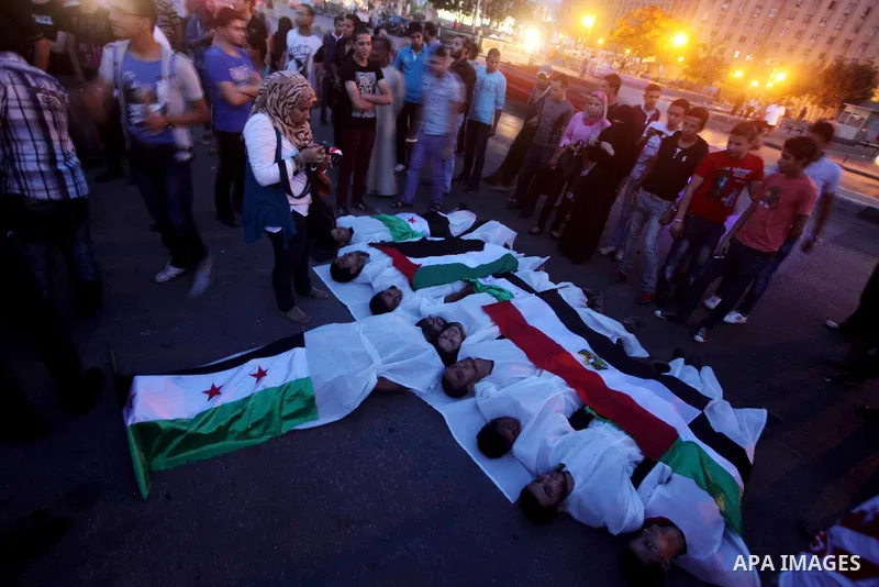 Protesters show solidarity with victims of massacre of Houla during a protest in front of the Syrian embassy in Cairo, Egypt, 31 May 2012. A massacre was reported in the central Syrian city of Houla over the weekend, how...