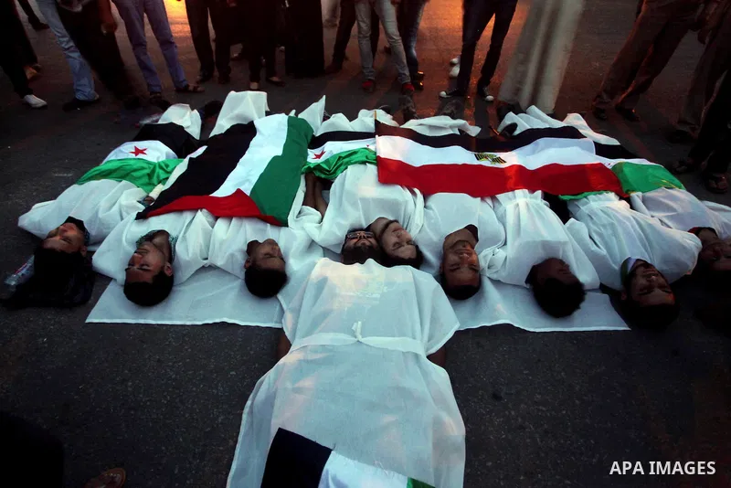 Protesters show solidarity with victims of massacre of Houla during a protest in front of the Syrian embassy in Cairo, Egypt, 31 May 2012. A massacre was reported in the central Syrian city of Houla over the weekend, how...