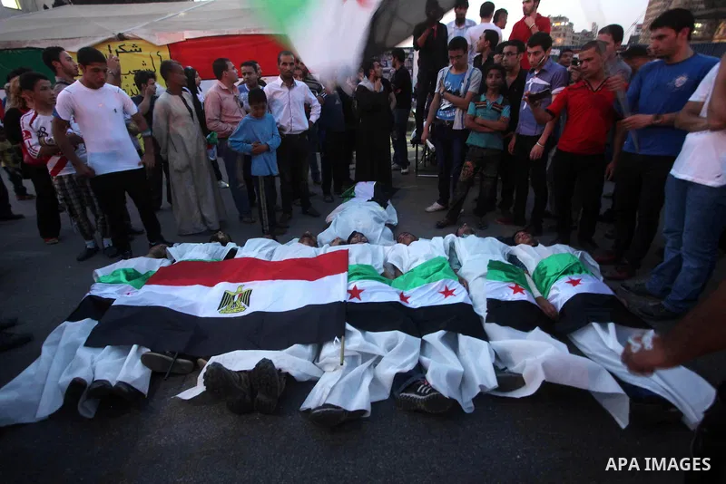 Protesters show solidarity with victims of massacre of Houla during a protest in front of the Syrian embassy in Cairo, Egypt, 31 May 2012. A massacre was reported in the central Syrian city of Houla over the weekend, how...
