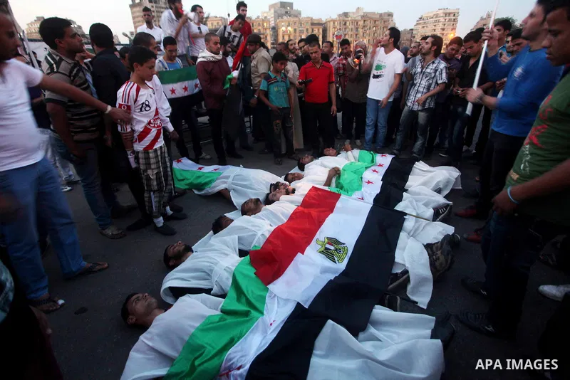Protesters show solidarity with victims of massacre of Houla during a protest in front of the Syrian embassy in Cairo, Egypt, 31 May 2012. A massacre was reported in the central Syrian city of Houla over the weekend, how...
