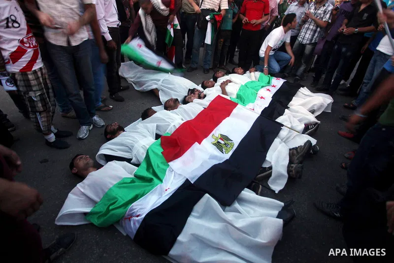 Protesters show solidarity with victims of massacre of Houla during a protest in front of the Syrian embassy in Cairo, Egypt, 31 May 2012. A massacre was reported in the central Syrian city of Houla over the weekend, how...
