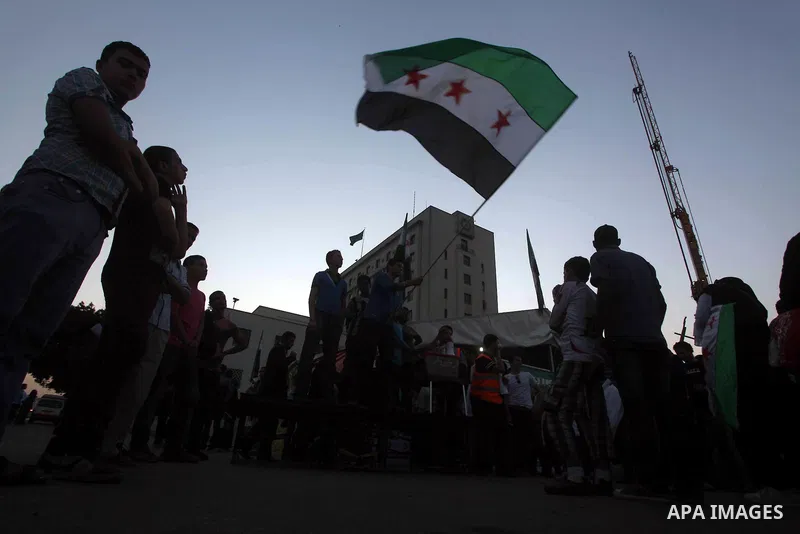 Protesters wave the revolutionary flag and shout slogans as they protest against the weekend massacre of Houla, in front of the Syrian embassy in Cairo, Egypt, 31 May 2012. A massacre was reported in the central Syrian c...