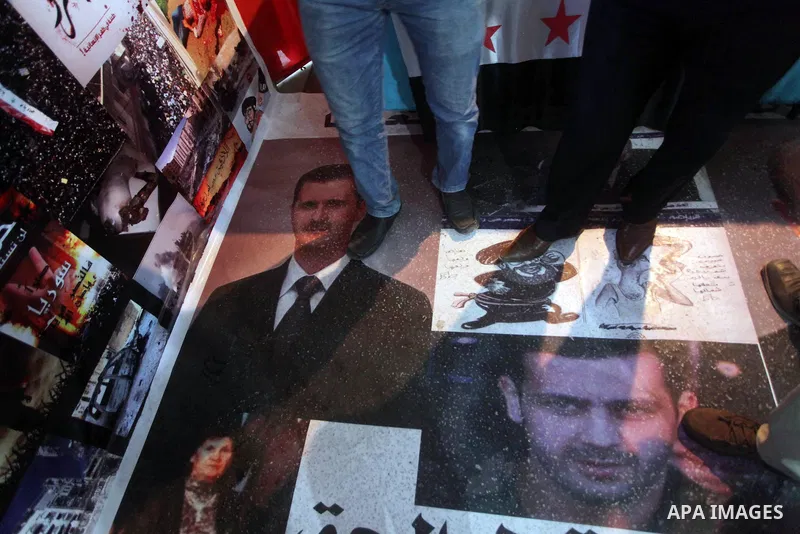 A protester tramples on the picture of Syrian President Bashar al-Assad during a protest against the weekend massacre of Houla, in front of the Syrian embassy in Cairo, Egypt, 31 May 2012. A massacre was reported in the...