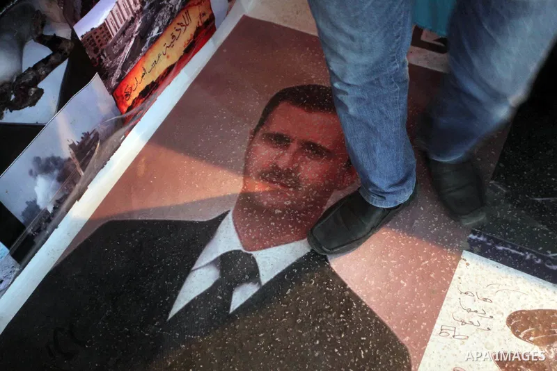 A protester tramples on the picture of Syrian President Bashar al-Assad during a protest against the weekend massacre of Houla, in front of the Syrian embassy in Cairo, Egypt, 31 May 2012. A massacre was reported in the...