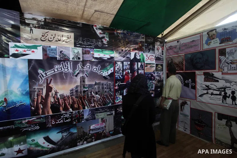 Protesters walk past posters of the Syria revolution during a protest against the weekend massacre of Houla, in front of the Syrian embassy in Cairo, Egypt, 31 May 2012. A massacre was reported in the central Syrian city...