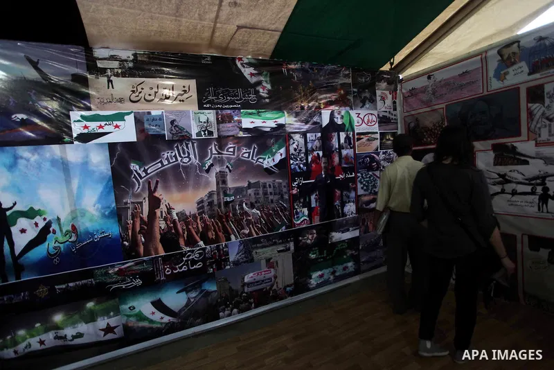 Protesters walk past posters of the Syria revolution during a protest against the weekend massacre of Houla, in front of the Syrian embassy in Cairo, Egypt, 31 May 2012. A massacre was reported in the central Syrian city...