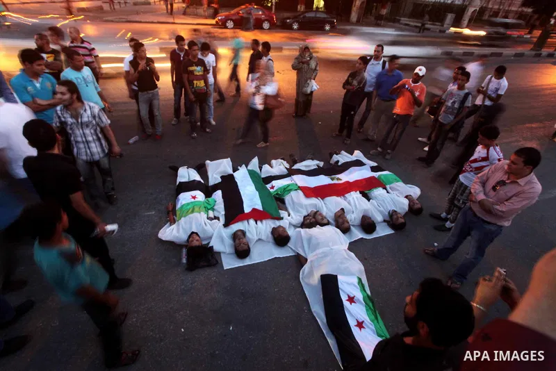 Protesters show solidarity with victims of massacre of Houla during a protest in front of the Syrian embassy in Cairo, Egypt, 31 May 2012. A massacre was reported in the central Syrian city of Houla over the weekend, how...