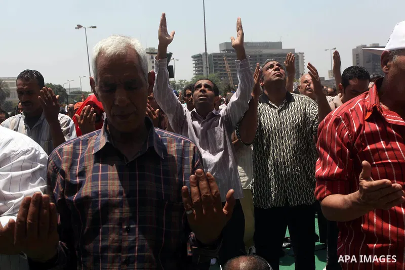 Egyptian protesters perform the weekly Friday noon prayer in Cairo's landmark Tahrir square during a demonstration against Egyptian presidential runoff candidate Ahmed Shafiq, an ex-prime minister under the ousted regime...