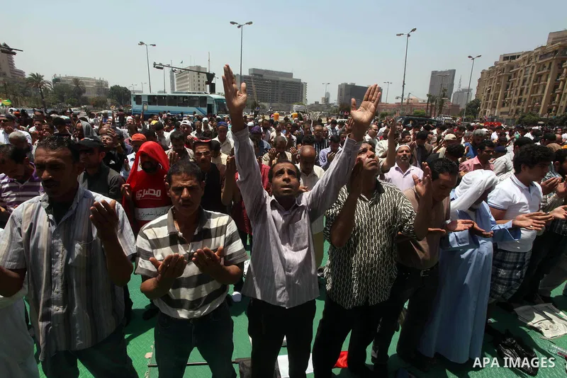 Egyptian protesters perform the weekly Friday noon prayer in Cairo's landmark Tahrir square during a demonstration against Egyptian presidential runoff candidate Ahmed Shafiq, an ex-prime minister under the ousted regime...